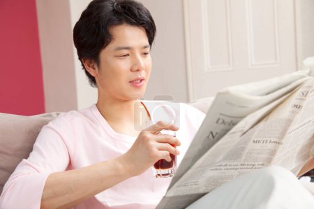 Foto de Hombre leyendo periódico bebiendo soda - Imagen libre de derechos