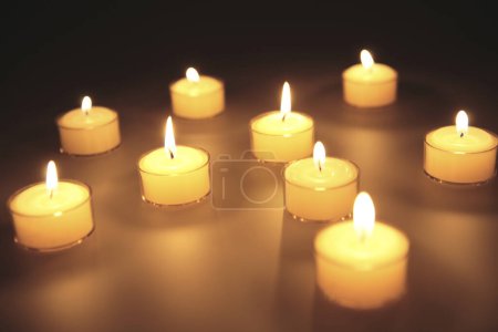 Téléchargez les photos : Beaucoup de bougies allumées sur fond noir - en image libre de droit
