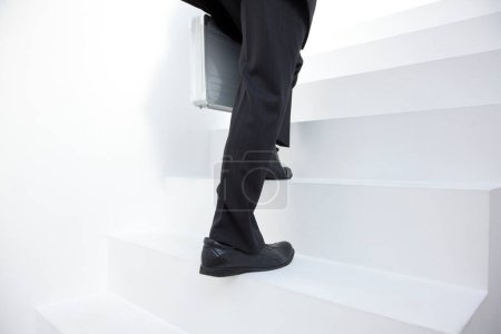 Téléchargez les photos : Vue de la section basse de l'homme d'affaires monter les escaliers - en image libre de droit