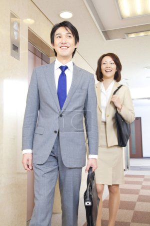 Photo for Confident Japanese businesspeople standing in corridor - Royalty Free Image