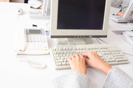 Foto de Una persona que escribe en un teclado de ordenador en un escritorio - Imagen libre de derechos