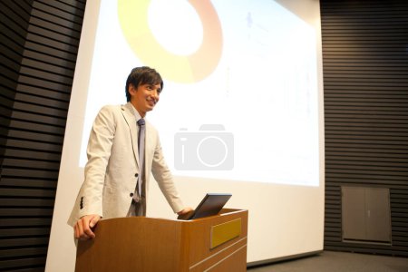 Téléchargez les photos : Asiatique homme debout à un podium - en image libre de droit