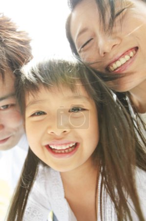 Téléchargez les photos : Portrait de famille heureuse de trois dans le parc - en image libre de droit