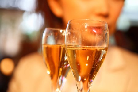 Foto de Vista de cerca de las mujeres tintineo vasos con champán en el restaurante - Imagen libre de derechos