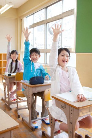 Téléchargez les photos : Enfants japonais assis en classe pendant la leçon - en image libre de droit