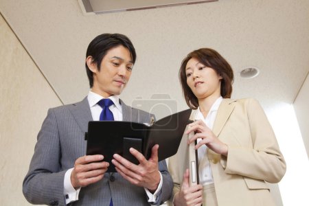 Photo for Confident Japanese businesspeople standing in corridor - Royalty Free Image