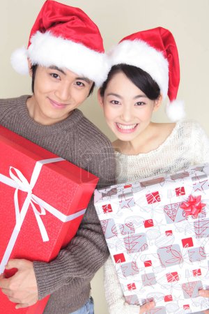 Téléchargez les photos : Jeune couple japonais avec cadeaux de Noël, gros plan portrait - en image libre de droit