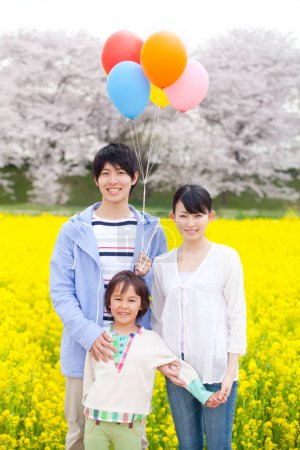 Téléchargez les photos : Portrait de la famille japonaise heureuse avec des ballons d'hélium colorés - en image libre de droit