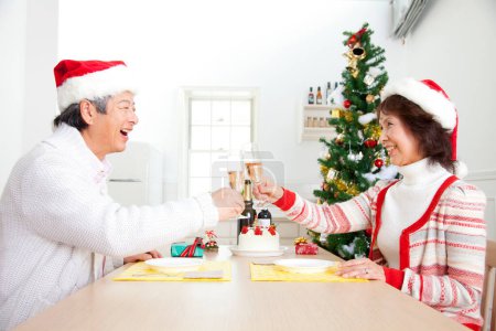 Photo for Asian senior man and woman  toasting champagne  Christmas at home - Royalty Free Image
