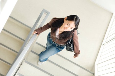 Téléchargez les photos : Jeune étudiante japonaise marchant dans les escaliers à l'université - en image libre de droit