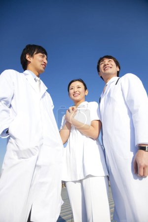 Téléchargez les photos : Trois jeunes asiatiques médecins debout ourdoors - en image libre de droit