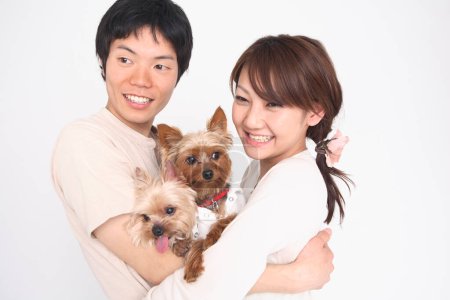 a man and woman holding  dogs and smiling