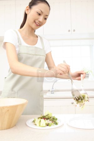 Téléchargez les photos : Belle asiatique ménagère cuisine dans cuisine - en image libre de droit
