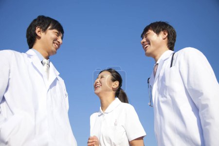 Téléchargez les photos : Trois jeunes asiatiques médecins debout ourdoors - en image libre de droit