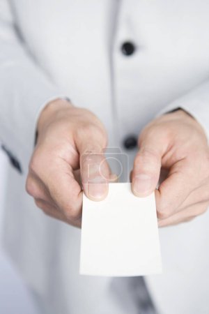 Foto de Hombre de negocios con tarjeta de visita en blanco, aislado sobre fondo blanco, espacio de copia - Imagen libre de derechos