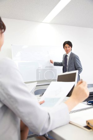 Photo for A man in a suit is pointing at a whiteboard - Royalty Free Image