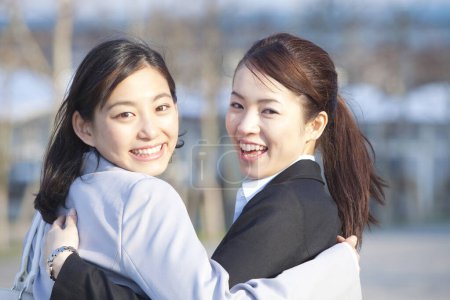 Photo for Two women in business clothes  hugging - Royalty Free Image