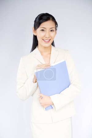 Photo for Portrait of a young businesswoman standing with folder - Royalty Free Image