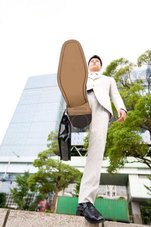 Téléchargez les photos : Asiatique homme d'affaires en costume marche dans la ville - en image libre de droit