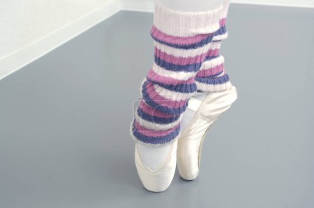 Foto de Female ballerina with pointe shoes on  background - Imagen libre de derechos