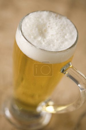 Foto de Taza de cerveza con espuma en la mesa, vista de cerca - Imagen libre de derechos