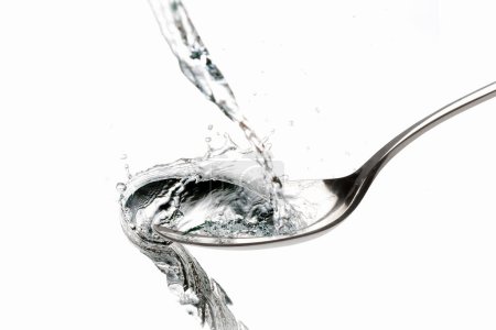 Foto de Salpicadura de agua en la cuchara sobre fondo blanco - Imagen libre de derechos
