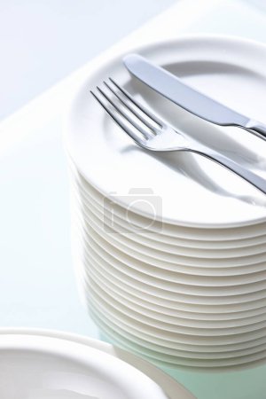 Photo for Clean white plates and cutlery on table - Royalty Free Image