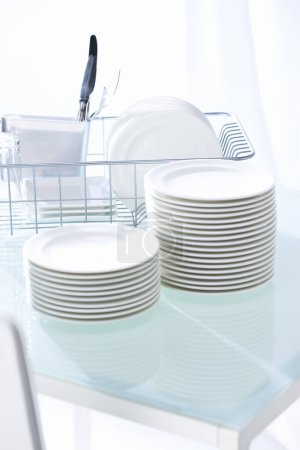 Foto de Platos blancos limpios en la mesa en la cocina - Imagen libre de derechos