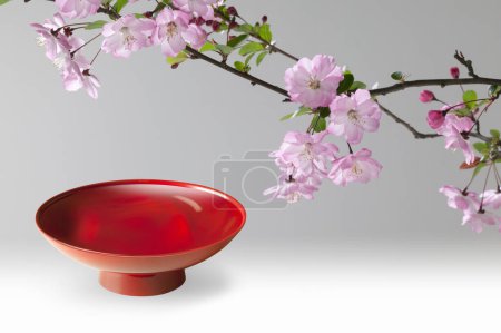 Photo for Red bowl for Japanese sake and blooming cherry flowers, close up view - Royalty Free Image