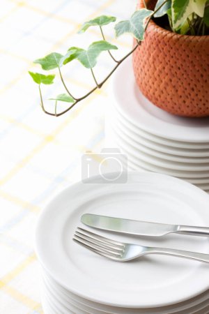 Téléchargez les photos : Fourchette et couteau sur plaque blanche. Ivy plante sur la table - en image libre de droit