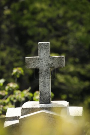 Foto de Cruz de piedra sobre la tumba en el cementerio - Imagen libre de derechos