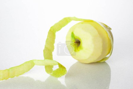 Téléchargez les photos : Pomme verte fraîche pelée sur fond blanc - en image libre de droit