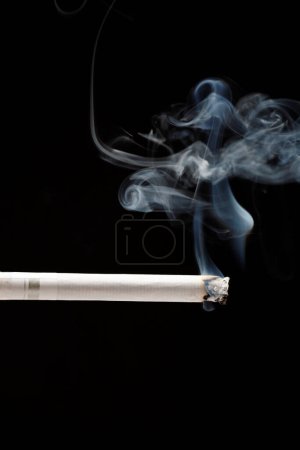 Téléchargez les photos : Cigarettes et fumée de tabac sur fond noir - en image libre de droit
