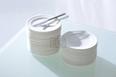 Téléchargez les photos : Assiettes et couverts blancs propres sur la table - en image libre de droit