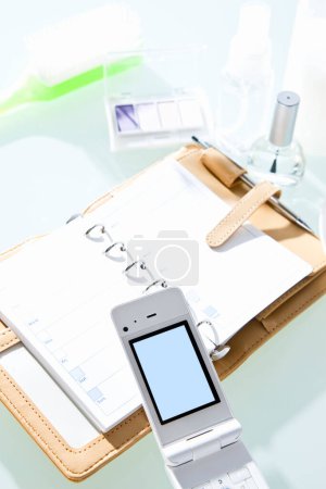 Photo for Mobile phone with female accessories on table - Royalty Free Image
