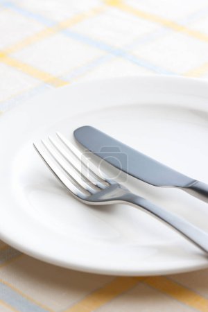 Foto de Tenedor y cuchillo en plato blanco - Imagen libre de derechos