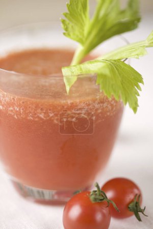 Foto de Fresh tomato juice in glass on table - Imagen libre de derechos