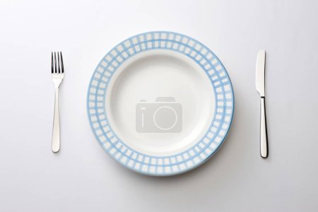 Téléchargez les photos : Fourchette, couteau et assiette sur fond blanc - en image libre de droit