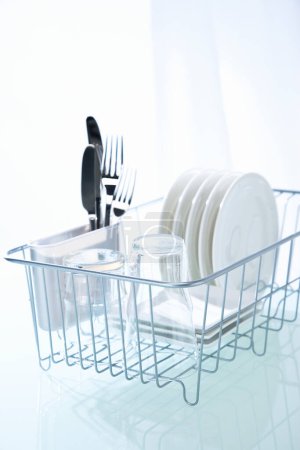 Foto de Platos limpios en lavavajillas estante en la mesa de la cocina limpia - Imagen libre de derechos