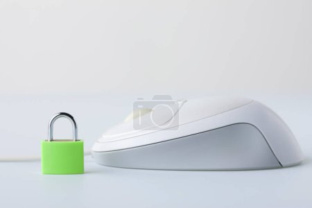 Foto de Computer mouse with small padlock on white background - Imagen libre de derechos
