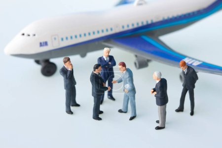 Photo for Miniature businesspeople figurines and airplane model - Royalty Free Image