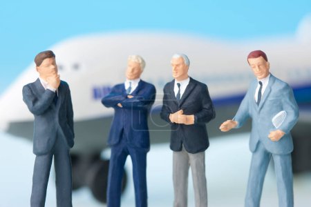Photo for Miniature businesspeople figurines and airplane model - Royalty Free Image