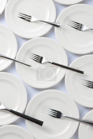 Téléchargez les photos : Ensemble de plats propres sur fond blanc. Fourchettes sur plaques blanches - en image libre de droit