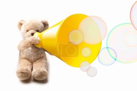 Téléchargez les photos : Un ours en peluche avec haut-parleur haut-parleur sur fond blanc avec bulles, isolé - en image libre de droit
