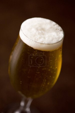 Foto de Taza de cerveza con espuma sobre fondo oscuro - Imagen libre de derechos