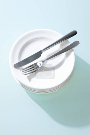 Téléchargez les photos : Assiettes blanches, fourchette et couteau sur fond de table - en image libre de droit