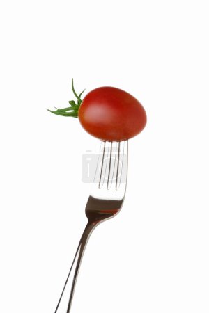 Photo for Fresh ripe tomato in fork isolated on white background - Royalty Free Image