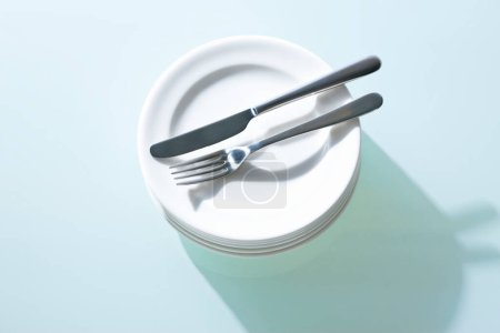 Photo for White plates, fork and knife  on table  background - Royalty Free Image