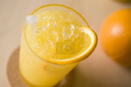Foto de Zumo de naranja fresco con hielo y rodaja de naranja en vaso - Imagen libre de derechos