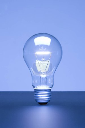 Téléchargez les photos : Ampoule sur fond bleu. idée créative - en image libre de droit